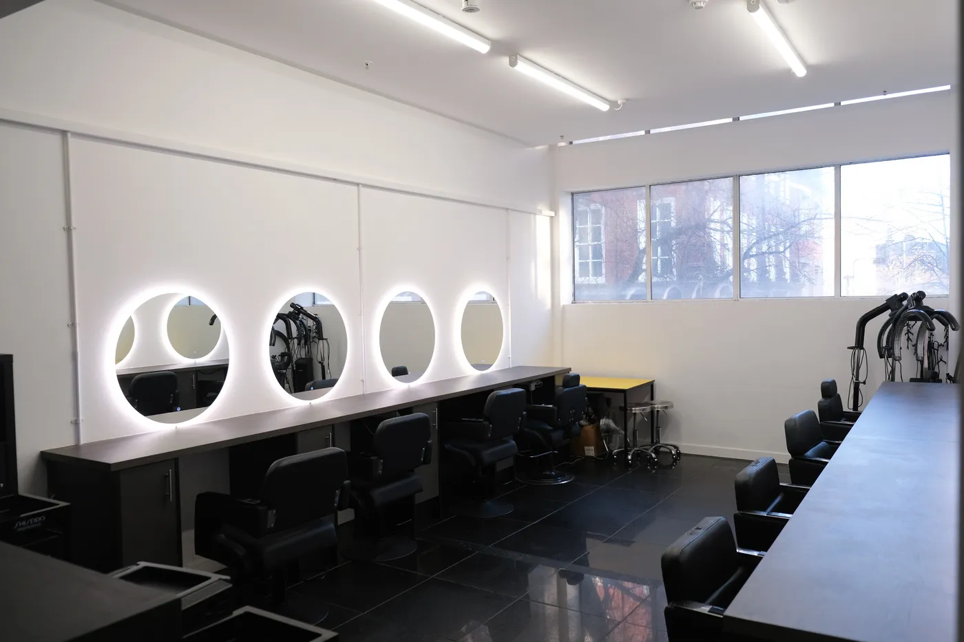 The styling floor at Harbour Hair, with backlit round mirrors and styling chairs