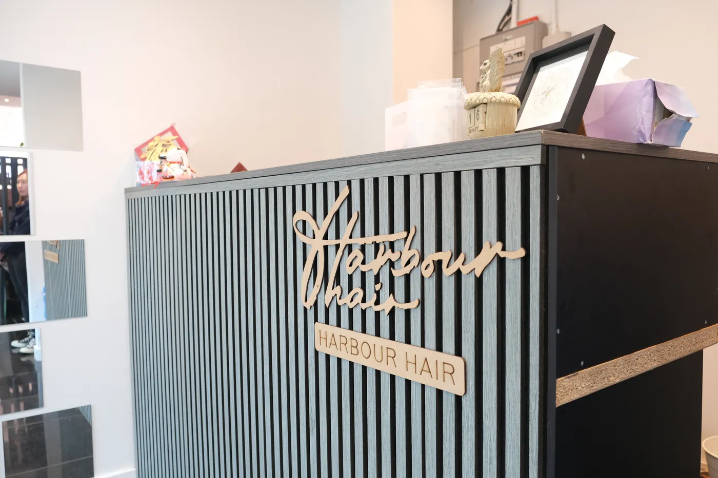 Reception desk featuring the Harbour Hair sign