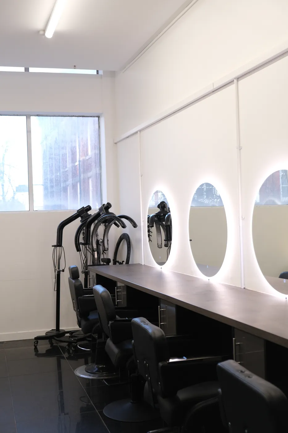 Styling area with natural light and professional hood dryers